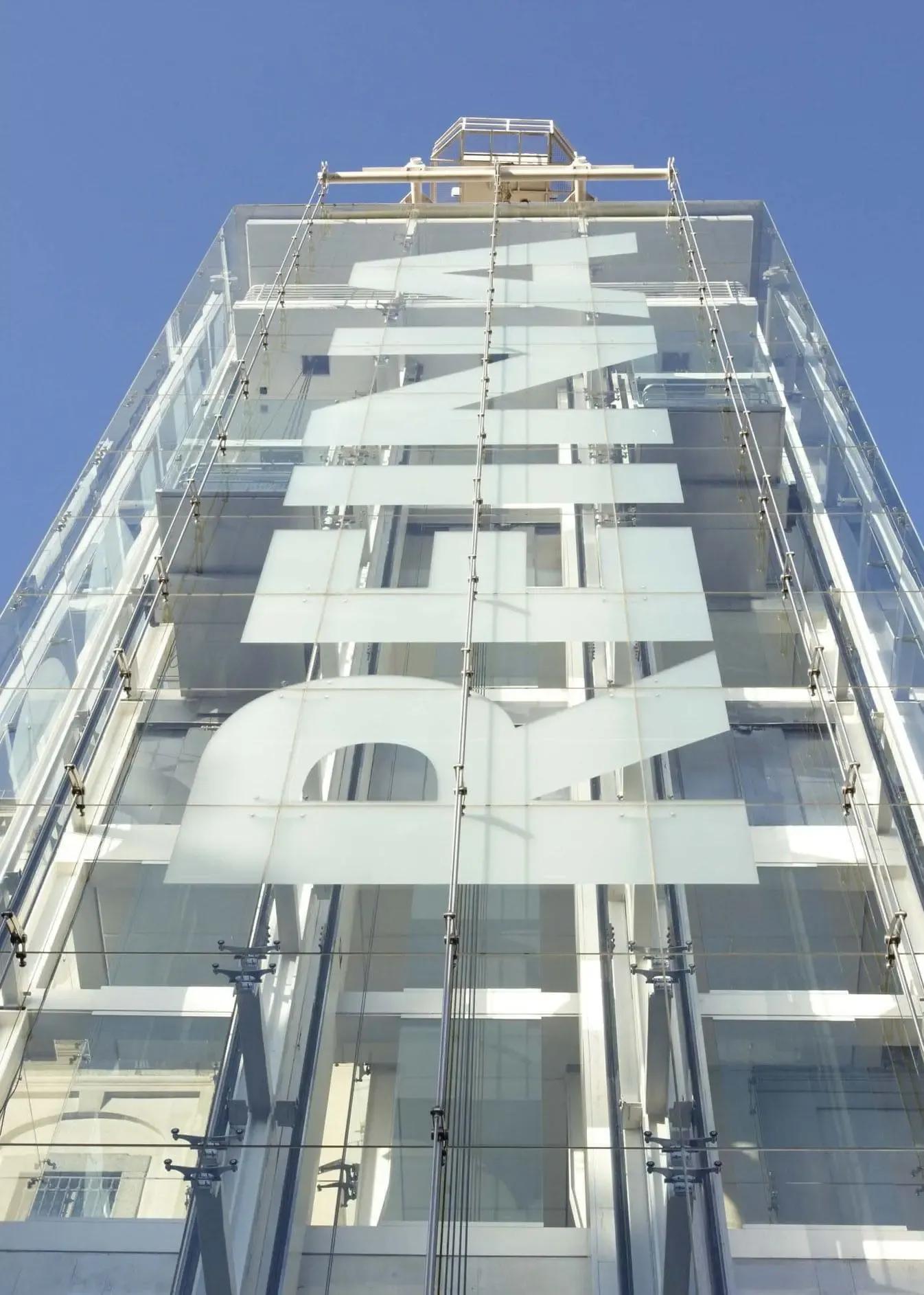 Exterior view of the Sabatini Building at Museo Reina Sofía in Madrid, featuring a vertical banner on its façade.
