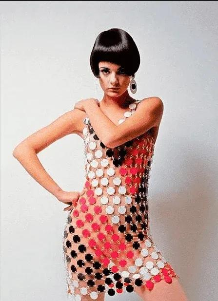 Model wearing a red and white disc-link dress by Paco Rabanne