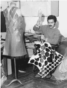 Paco Rabanne working in his studio, holding fabric with a geometric print